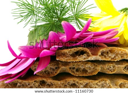 Three crisp-bread, two flowers and green grass. Based on a tidy pile