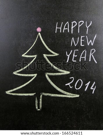 Christmas tree and Happy new year written on blackboard