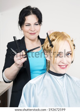 Hairdresser cuts (trims) blond long hair