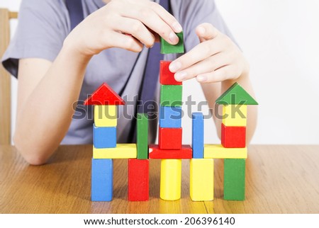 Man builds the house of children\'s toy blocks
