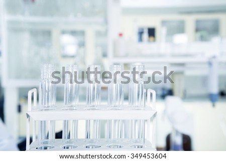 Group of laboratory flasks with a clear liquid on desk in laboratory interior.