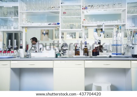 Interior of clean modern white medical or chemical laboratory background. Laboratory concept with caucasian male chemist. Horizontal template for a poster, webpage or leaflet.