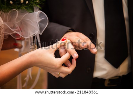 bride groom wears the ring wedding