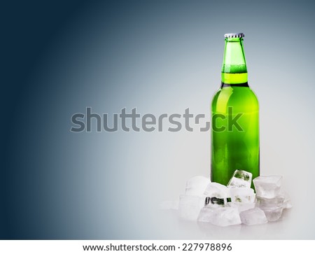 beer bottle in ice cubes on blue background