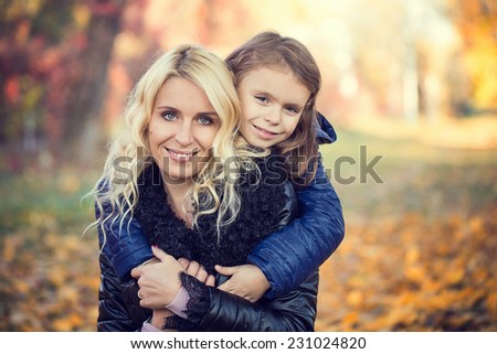 Daughter hugging her mother autumn park