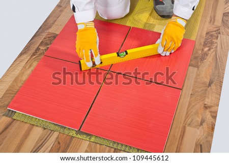 Worker levels Tiles applied on old wooden Floor reinforced net