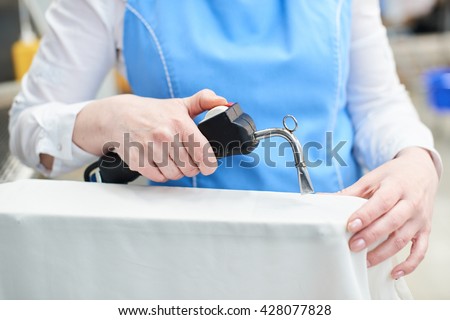 Hand Laundry worker in the process of removing stains by using a special dry-cleaning