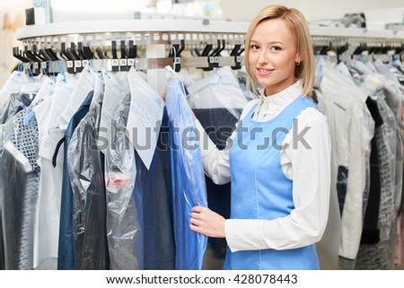 Portrait of a girl Laundry worker on the background of the coat racks at the dry cleaners