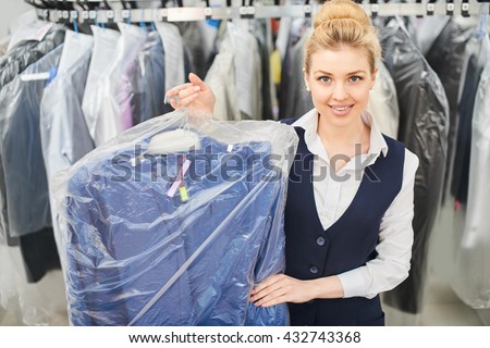 Girl Laundry worker holding a hanger Packed with clean clothes at the dry cleaners