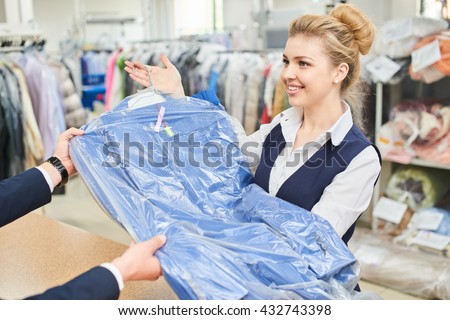 Girl Laundry worker pays into the hands of clean clothes at the dry cleaners