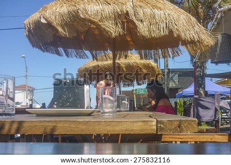 PUNTA DEL ESTE, URUGUAY, FEBRUARY - 2015 - Sunny day at rustic style outdoors restaurant with people in La barra, a picturesque seaside resort near Punta del Este in Uruguay.