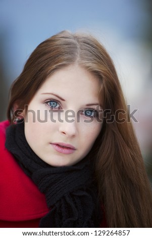 sad gray-eyed girl in red coat and black scarf