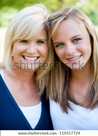 Mother and teenage daughter outside smiling