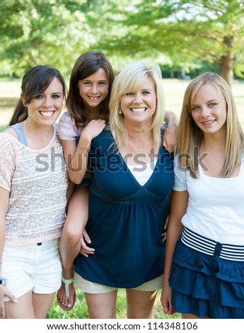 Mother and three daughters outside smiling