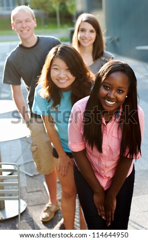 Multi-ethnic group of teenagers outside smiling