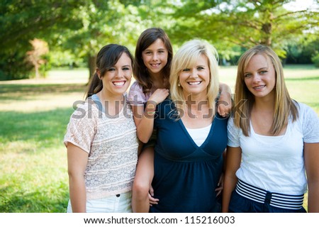 Mother and three daughters oustide smiling