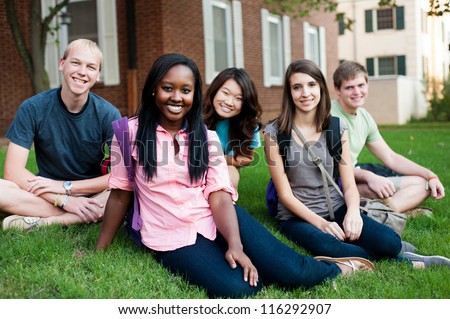 Diverse group of friends outside sitting on a lawn