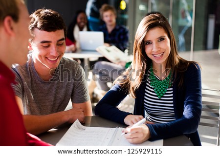 Student outside studying while smiling