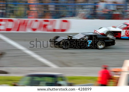 Motion blur of stock car race cars crossing the finish line