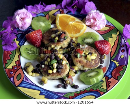 Focus is on front 2 crab cakes. Crab cakes with Tropical fruit salsa.