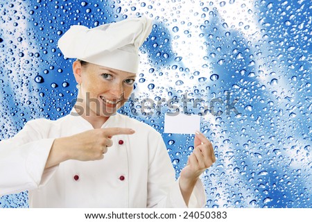 Beautiful cook woman holding blank card over a abstract background