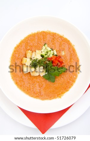 White bowl of tomato soup on white background
