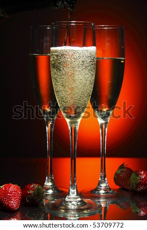 Champagne poured in to the glass (isolated on red