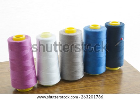 Thread Spool on Sewing Table with White Background / Sewing Thread with needles / Colourful Thread Spool / Machinery / Traditional Sewing