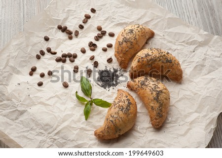 croissant bread on the buffet line, hot coffee, fresh homemade croissants on wooden table, selective focus, some croissants on parchment paper surface, coffee beans, mint.