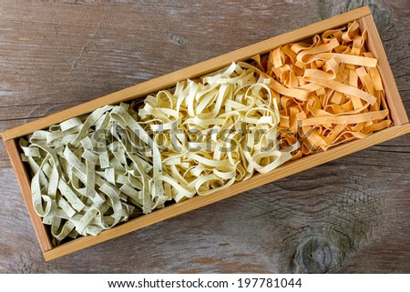 colorful pasta tagliatelle in wooden box