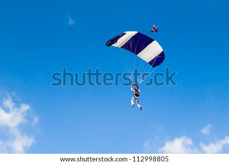 Parachute jumper against blue sky