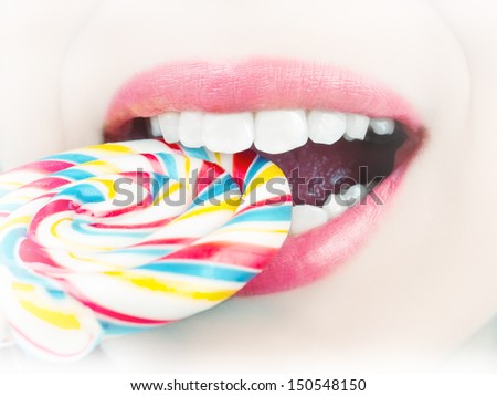 Pearl white female teeth biting candy