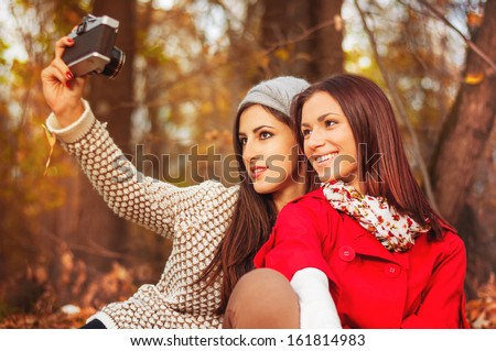Vintage girls taking self shots  in the park