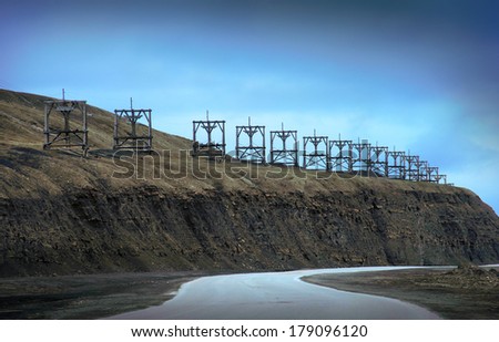 Arctic scenic view with silhouette of old deserted coal mining transfer towers and twisty road from Longyearbyen to airport of Spitsbergen (Svalbard island), Norway, Northern Europe