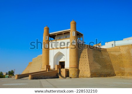 Beautiful sunny day view of ancient fortress - The Ark and the ceremonial entrance into it against the background of blue sky in Historic Center of Bukhara, Uzbekistan, Central Asia