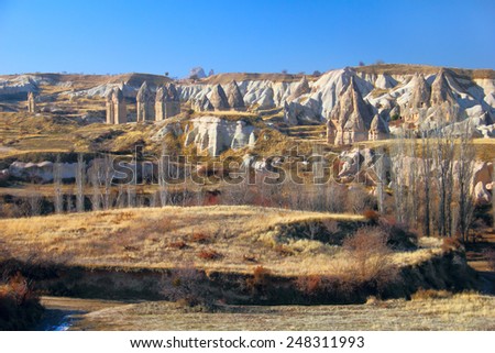 Beautiful barren landscape - ashen mountains (volcanic rocks) - eerie carved and hollowed out structures at the evening in Sward Valley, Goreme, Cappadocia, Central Anatolia, Turkey