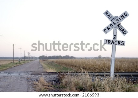 country road railroad crossing in evening light