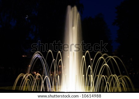 An impressive view of a water fountain at night at its full height.