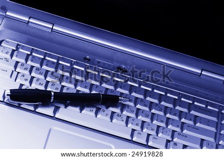 Business tools. Pen and keyboard of laptop.