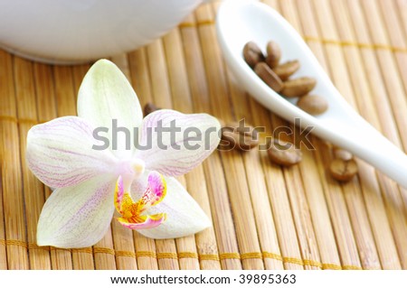 coffee beans with spoon and orchid flower