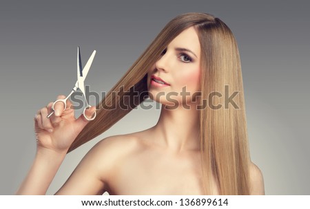 Hair. Beautiful Blonde Girl. Healthy Long Hair. Beauty Model. Scissors
