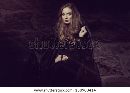 fashion photo of gothic girl in Halloween dress against the wall
