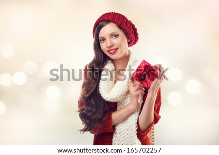 Happy young woman with christmas present in hands posing