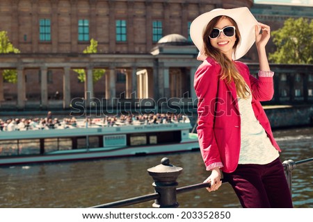 Beautiful girl wearing summer hat and sunglasses at riverside