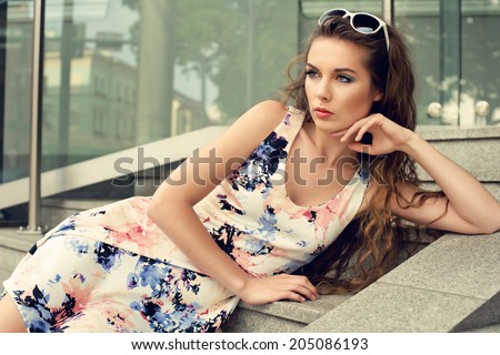 young fashion woman wearing dress posing on stairs
