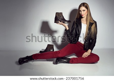 young woman posing in leather jacket and boots