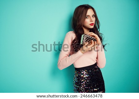 fashion photo of beautiful young woman in nice clothes and small hand purse. Red lips