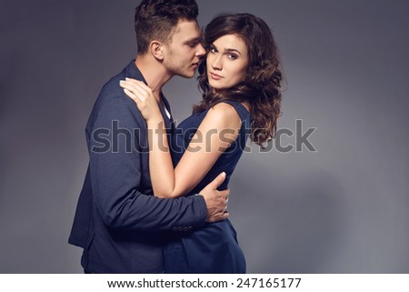 Fashion photo of sexy elegant couple in the tender passion. Studio portrait