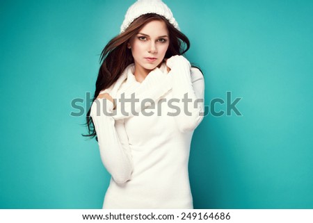 beautiful happy young woman in white warm long turtleneck sweater, winter cap. Fashionable clothes