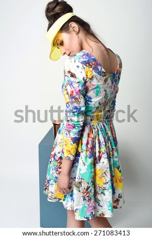 beautiful young woman in nice spring dress, posing in studio, plastic visor. Fashion photo